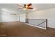 Open loft area featuring brown carpeting, ceiling fans, and a railing at 12217 W Planada Ln, Sun City, AZ 85373