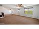 Open loft area featuring three windows, ceiling fans and brown carpeting at 12217 W Planada Ln, Sun City, AZ 85373