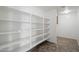 Walk-in pantry featuring ample shelving space and tile flooring at 12217 W Planada Ln, Sun City, AZ 85373