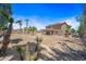 Spacious backyard with mature palm trees, desert landscaping, and covered patio at 12745 W Monte Vista Rd, Avondale, AZ 85392
