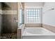 Bright bathroom with a soaking tub, glass enclosed shower, and tile accents at 12745 W Monte Vista Rd, Avondale, AZ 85392