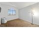 Vacant bedroom with carpet flooring, a window, and a modern lamp at 12745 W Monte Vista Rd, Avondale, AZ 85392