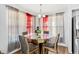 Dining area features a glass table, upholstered chairs, and windows with draped curtains at 12745 W Monte Vista Rd, Avondale, AZ 85392