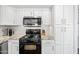 White kitchen cabinets, granite countertops, stainless steel microwave, and gas range oven at 12745 W Monte Vista Rd, Avondale, AZ 85392