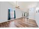 Bright living room featuring stylish wood floors, large windows, ceiling fan, and ample natural light creating a cozy atmosphere at 12745 W Monte Vista Rd, Avondale, AZ 85392