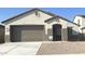 Charming single-story home with a neutral color scheme, attached two-car garage, and low-maintenance gravel landscaping at 25336 W Bowker St, Buckeye, AZ 85326