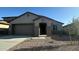 Charming single-story home with a two-car garage and low maintenance desert landscaping in the front yard at 25336 W Bowker St, Buckeye, AZ 85326
