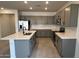 Spacious kitchen with gray cabinets, an island with sink, stainless steel appliances, and tile flooring at 25342 W Bowker St, Buckeye, AZ 85326