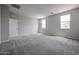 Neutral bedroom offers soft carpet, light gray walls, and a window that brings in natural light at 2557 E Music Mountain Ave, Apache Junction, AZ 85119