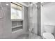 Modern gray bathroom featuring a glass shower with built-in shelving and a toilet at 319 E Hackamore St, Mesa, AZ 85201
