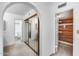 Hallway featuring arched doorways, a cedar closet, and a bathroom with a sliding glass shower door at 319 E Hackamore St, Mesa, AZ 85201