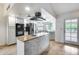 Modern kitchen featuring stainless steel appliances, white cabinetry, a stylish island, and an adjacent dining area at 319 E Hackamore St, Mesa, AZ 85201