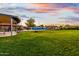 Large grassy backyard featuring mature trees, pool, outdoor dining, and ample space for recreation at 368 E Campbell Rd, Chandler, AZ 85225