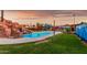 Scenic pool area with rock waterfall feature, complemented by a spacious yard and covered outdoor seating areas at 368 E Campbell Rd, Chandler, AZ 85225