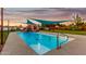Inviting pool area with a rock waterfall feature, a shade structure, and meticulously maintained surrounding landscaping at 368 E Campbell Rd, Chandler, AZ 85225