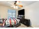Bedroom with mounted TV, natural light, and a dresser at 11259 W Locust Ln, Avondale, AZ 85323
