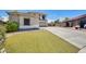Well-maintained home featuring a lush lawn, desert landscaping, and a spacious driveway at 11259 W Locust Ln, Avondale, AZ 85323
