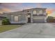 Two-story home with a large driveway, desert landscaping, and a welcoming red front door at 11259 W Locust Ln, Avondale, AZ 85323