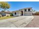 Attractive two-story home with a large driveway, desert landscaping, and an attached garage at 11259 W Locust Ln, Avondale, AZ 85323