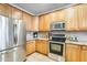 A well-lit kitchen featuring stainless steel appliances, granite countertops, and tiled backsplash at 11259 W Locust Ln, Avondale, AZ 85323