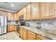Bright kitchen featuring wood cabinets, granite countertops, and stainless steel microwave oven at 11259 W Locust Ln, Avondale, AZ 85323