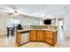 Well-lit kitchen featuring granite countertops, wood cabinetry, and views into the living and dining areas at 11259 W Locust Ln, Avondale, AZ 85323