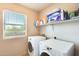 Bright laundry room with washer, dryer, and shelving for storage at 11259 W Locust Ln, Avondale, AZ 85323