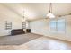 Bright living room with neutral carpet, tile flooring, and abundant natural light from multiple windows at 11259 W Locust Ln, Avondale, AZ 85323