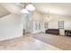 Open living area with neutral tile floors and a carpeted seating area, enhanced by modern lighting fixtures at 11259 W Locust Ln, Avondale, AZ 85323