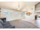 Spacious living room featuring a comfortable sofa, neutral carpet, tile floors, and natural lighting at 11259 W Locust Ln, Avondale, AZ 85323