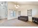 Inviting living room with carpeted and tiled areas, bright windows, and modern shelving at 11259 W Locust Ln, Avondale, AZ 85323