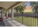 Covered patio area overlooking a spacious, fenced backyard with artificial turf and mature trees, providing shade and privacy at 11259 W Locust Ln, Avondale, AZ 85323