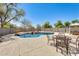 Inviting backyard boasts a rock-accented pool, patio, and outdoor seating, perfect for entertaining and relaxation at 11259 W Locust Ln, Avondale, AZ 85323