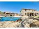 Backyard featuring a sparkling swimming pool, rock waterfall, and multiple seating areas for relaxation and entertainment at 11259 W Locust Ln, Avondale, AZ 85323