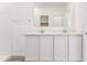 Modern bathroom features double sinks, white cabinets, a large mirror, and an open doorway at 12246 E Agave Ln, Florence, AZ 85132