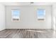 Sunlit bedroom with wood floors has two windows looking out to the property's perimeter wall at 12246 E Agave Ln, Florence, AZ 85132