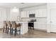 Bright white kitchen features modern appliances, white cabinets, a spacious island, and wood flooring at 12246 E Agave Ln, Florence, AZ 85132