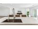 Bright kitchen island features white marble countertop, stainless steel sink, and views to the living room at 12246 E Agave Ln, Florence, AZ 85132