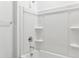 A pristine white shower and tub combination featuring built-in shelving and sleek chrome hardware at 12246 E Agave Ln, Florence, AZ 85132