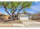 Single-story home featuring a two-car garage, stone accents, desert landscaping, and a large shade tree at 1320 E Binner Dr, Chandler, AZ 85225