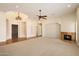 Open living room featuring a fireplace, tile floors at the entrance, and an elegant ceiling fan at 14112 N 12Th St, Phoenix, AZ 85022