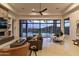 Stylish living room with desert views, a modern fan, and a stone fireplace at 15332 E Hidden Springs Trl, Fountain Hills, AZ 85268