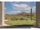 View of the backyard putting green, desert landscape, and golf course in background at 15332 E Hidden Springs Trl, Fountain Hills, AZ 85268
