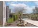 Beautiful landscaped yard features native plants, rocks, and mature trees at 15332 E Hidden Springs Trl, Fountain Hills, AZ 85268