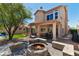 Expansive backyard with a stone fire pit, lush green lawn, covered patio, and outdoor seating at 162 W El Freda Rd, Tempe, AZ 85284