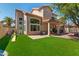 Large backyard with artificial grass, ' play equipment, and a covered patio at 162 W El Freda Rd, Tempe, AZ 85284