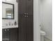 Bathroom vanity with dark cabinet and white marble countertop paired with a storage cabinet and toilet at 162 W El Freda Rd, Tempe, AZ 85284