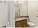 A half-bath featuring a framed mirror, bronze fixtures, an undermount sink, and a vanity with raised panel doors at 162 W El Freda Rd, Tempe, AZ 85284