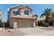 Two-story tan home featuring a two-car garage, complemented by desert landscaping and a palm tree at 162 W El Freda Rd, Tempe, AZ 85284
