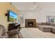 Warm living room featuring a fireplace, plush sofa, and a large TV for entertainment at 162 W El Freda Rd, Tempe, AZ 85284